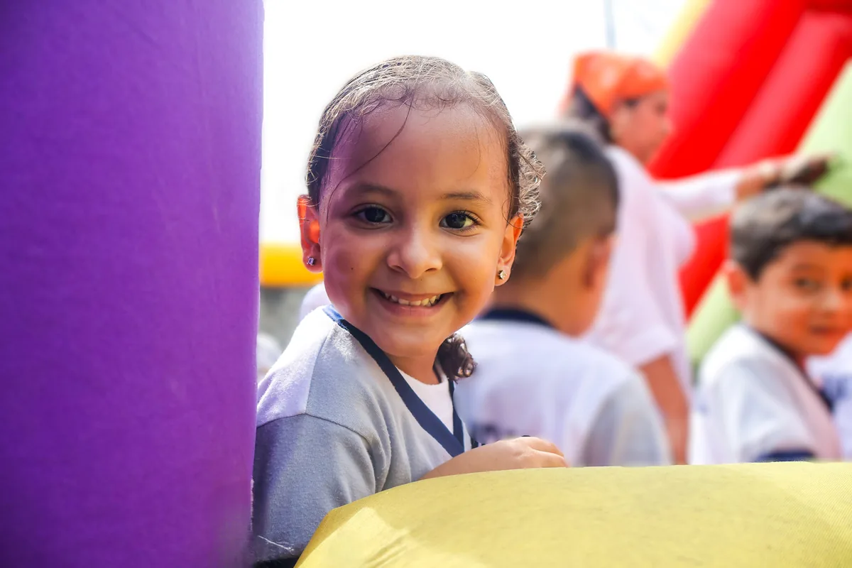 Niña de inicial sonriendo en los juegos del colegio