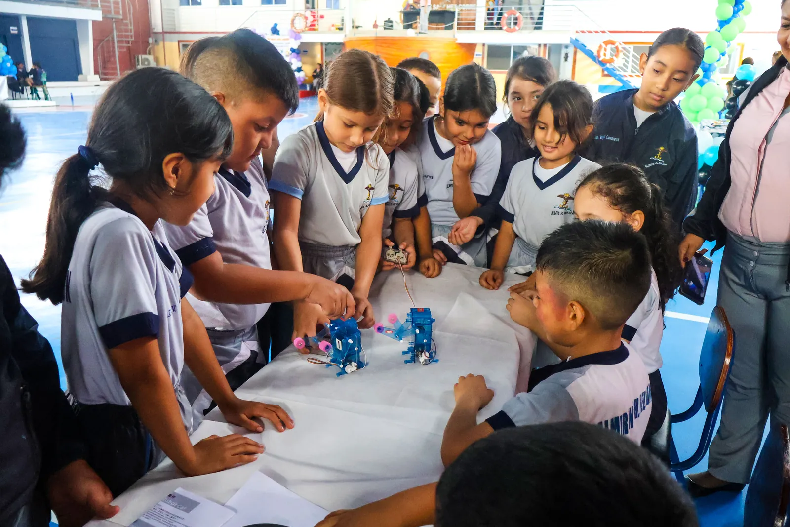 Niños mirando robots en la feria de robótica